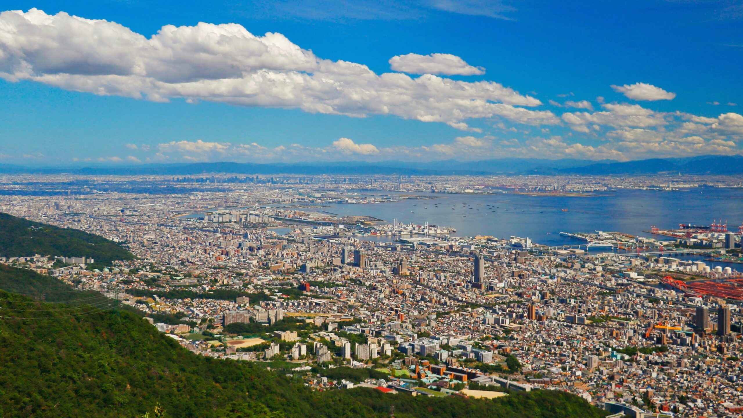 KAN-KOBE-01 · the city between mountain and harbour, low afternoon light — 16:9, 1920×1080