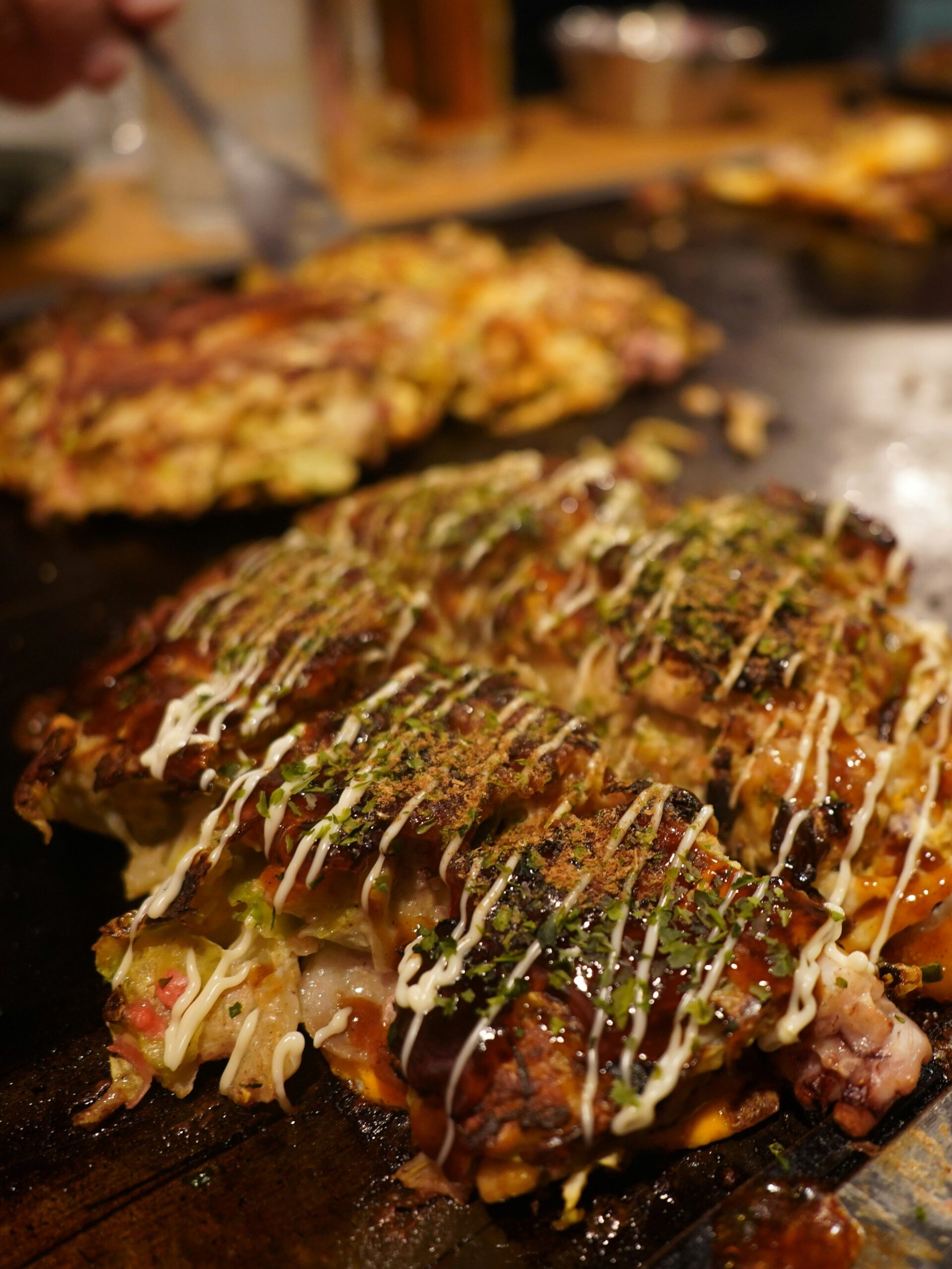 KAN-EAT-03 · okonomiyaki or udon counter, steam and hands — 3:4, 1200×1600