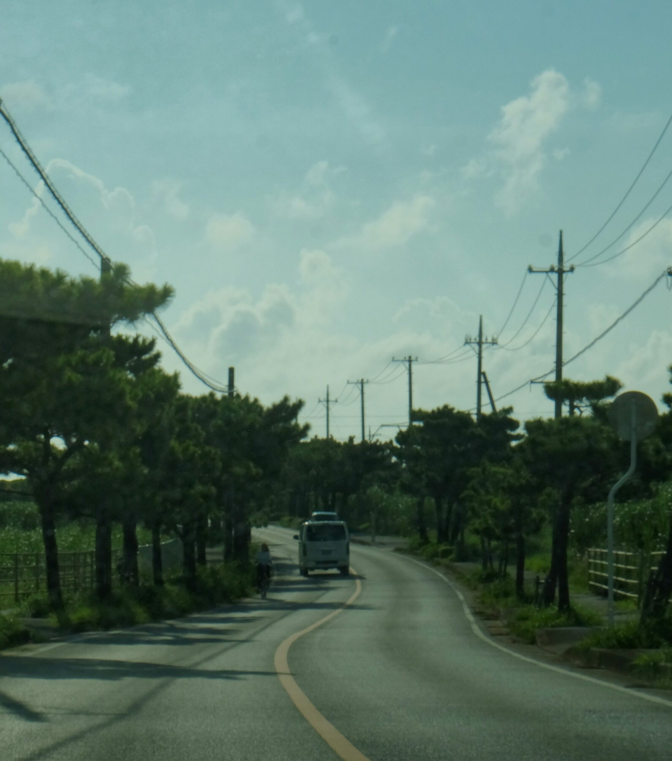 OKI-DAY-02 · driving the coast — road and sea through a windscreen or side window. 3:4, 1000×1333