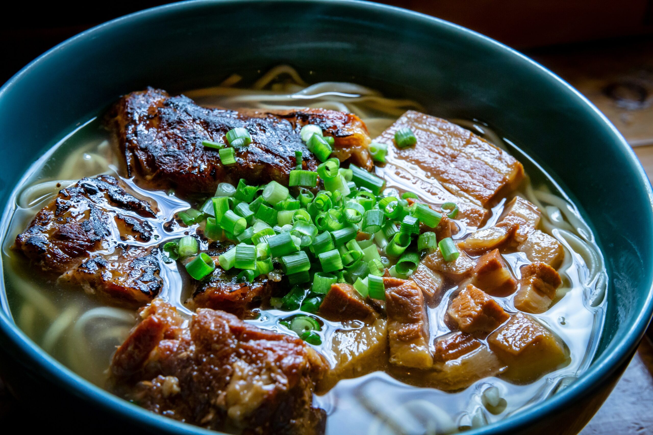 OKI-DAY-03 · Okinawa soba at a roadside shokudo, plain table, no styling. 3:2, 1500×1000