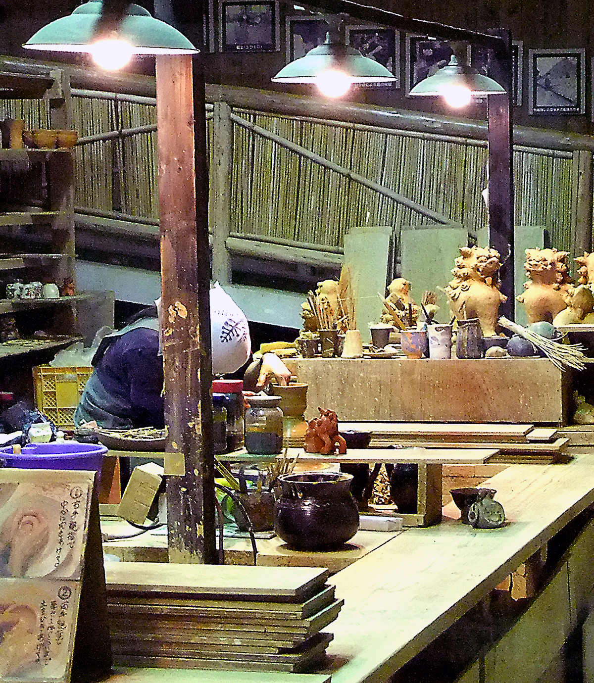 OKI-RYUKYU-02 · craft hands at work — a potter's wheel, glaze, or bingata dyeing. Close, unposed. 4:5, 1200×1500