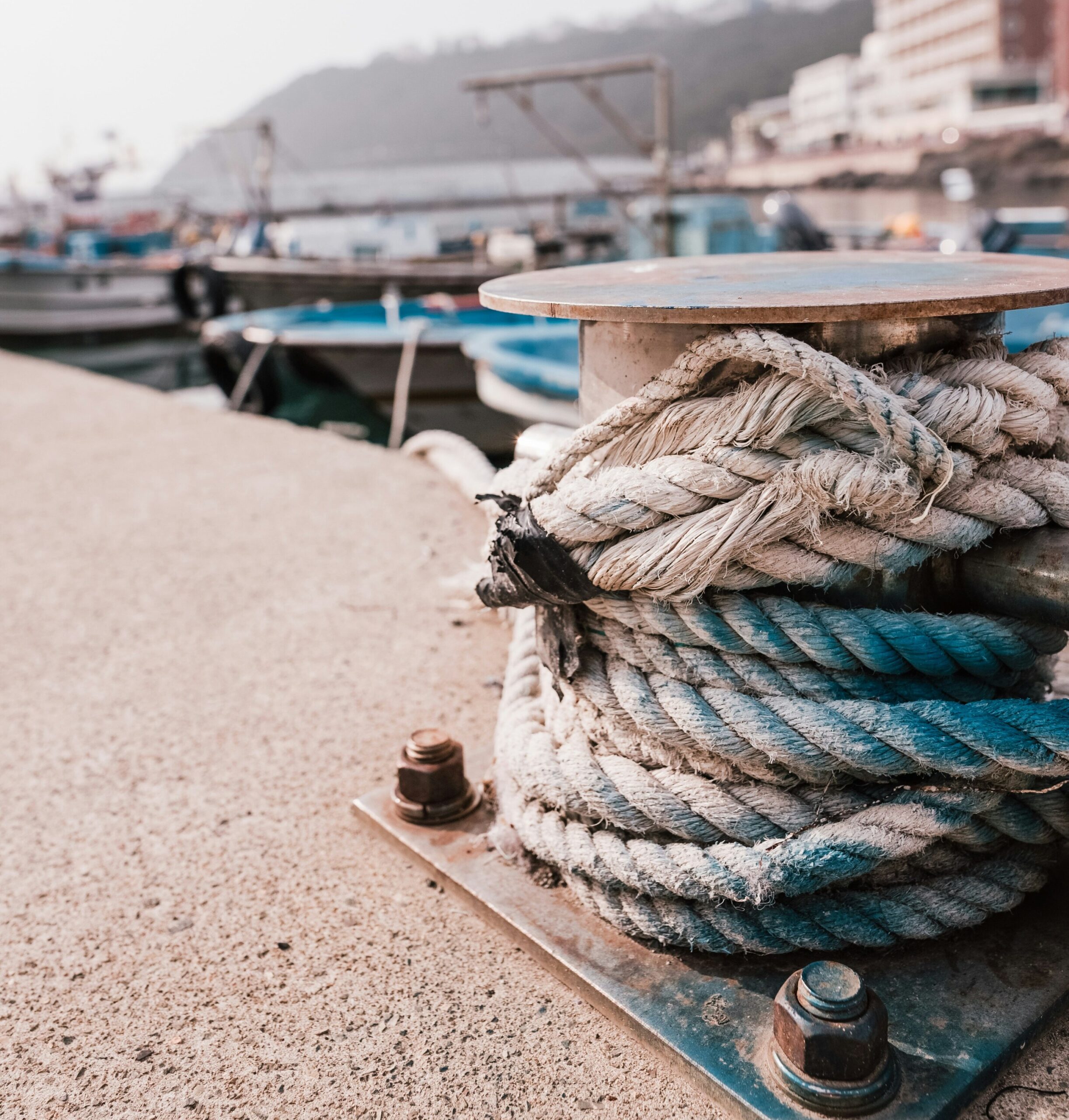 BS-COVER-02 · harbour detail — painted fishing boat hull, coiled rope, or faded coastal signage in morning light. 1:1, 1000×1000