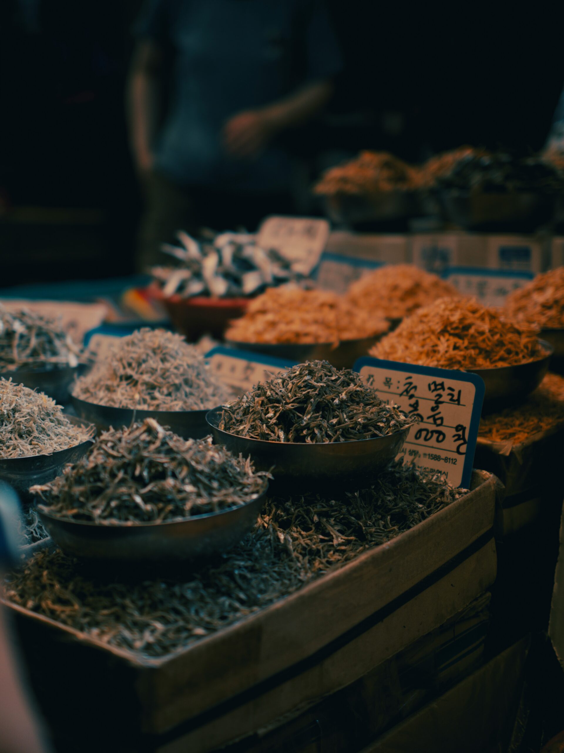 BS-MARKET-02 · hands preparing seafood at a local market, knife and water, close crop. 4:3, 1200×900