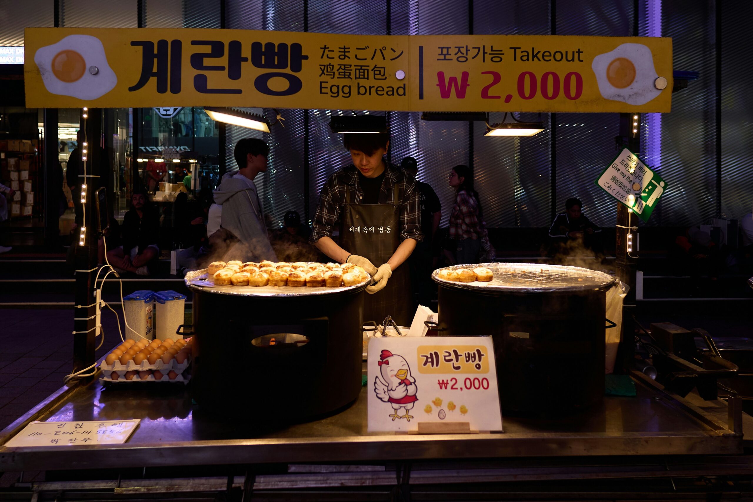 BS-NIGHT-03 · street food being cooked at night, steam under a bulb. 3:2, 1500×1000