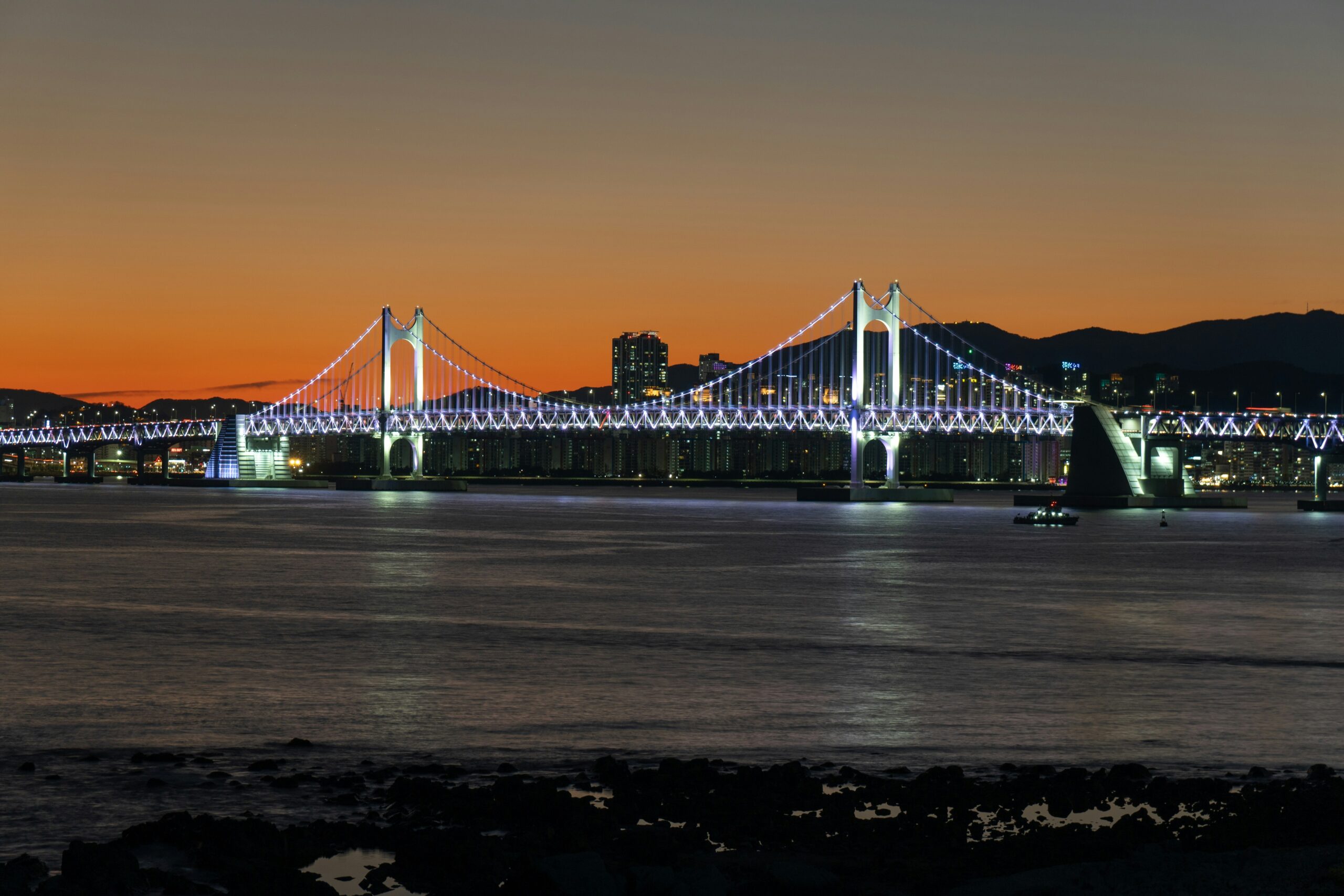 BS-PLAN-04 · bay lights reflected on water after dark. 3:2, 1200×800