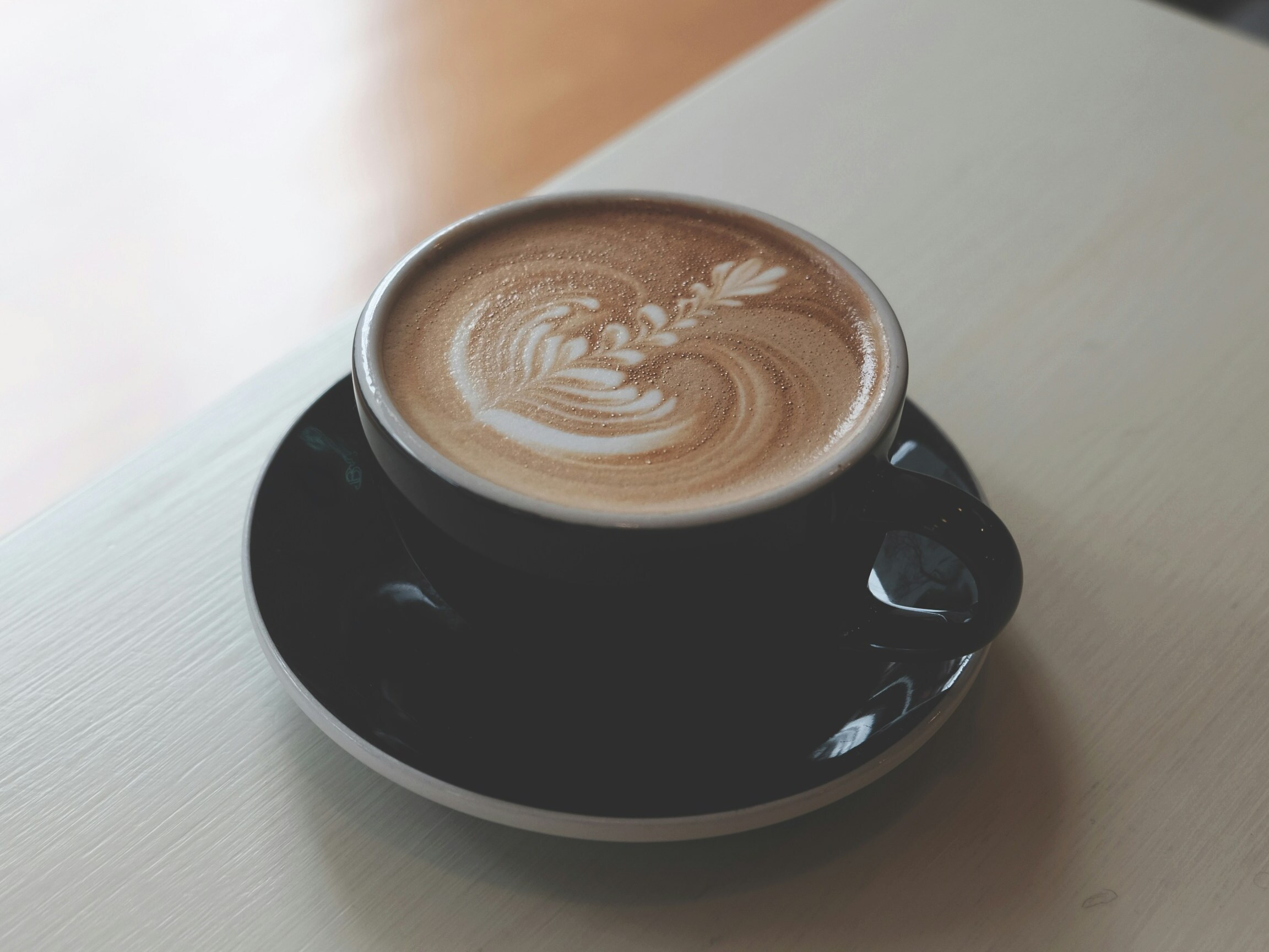 TOK-DETAIL-07 · a café cup on a wooden counter — 4:3, 1000×750